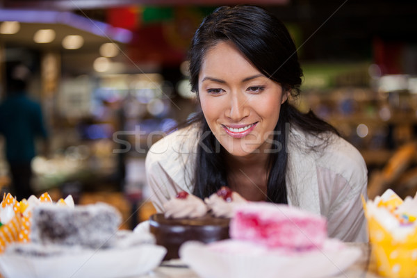 Happy woman selecting desserts from display Stock photo © wavebreak_media