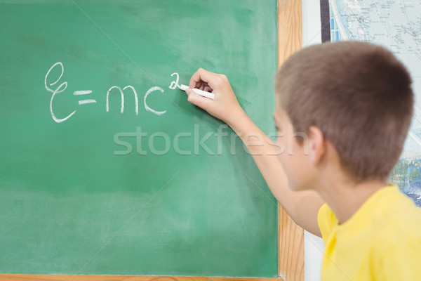 Cute pupil writing on chalkboard in a classroom Stock photo © wavebreak_media