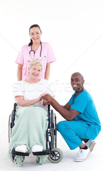 Doctors with a patient in a wheel chair smiling at the camera Stock photo © wavebreak_media