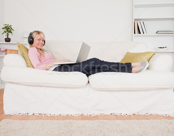 Jól kinéző nő zenét hallgat fejhallgató kanapé nappali Stock fotó © wavebreak_media