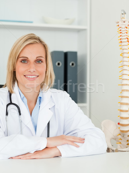 Smiling doctor with model spine next to her looks into camera in her office Stock photo © wavebreak_media
