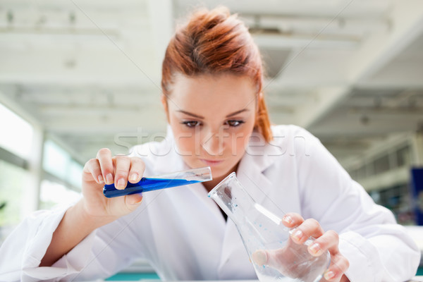 Beautiful serious scientist pouring liquid in a laboratory Stock photo © wavebreak_media