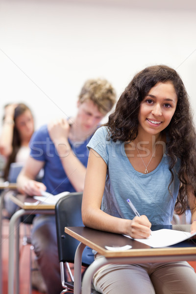 Stock photo: Portrait of smiling students working on an assignment in a classroom