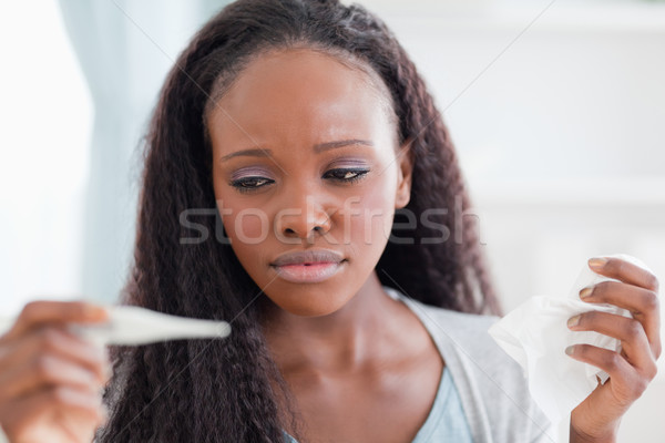 Close up of ill young woman measuring her temperature Stock photo © wavebreak_media