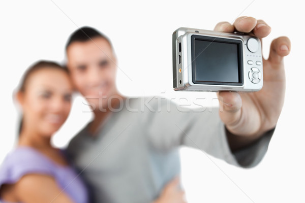 Camera being used to take a picture of young couple against a white background Stock photo © wavebreak_media