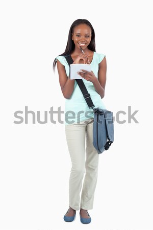 Smiling young student with scratchpad against a white background Stock photo © wavebreak_media