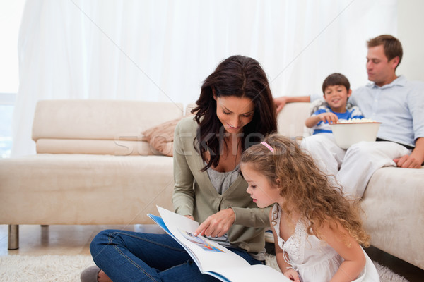 Stock photo: Mother showing photo album to her daughter