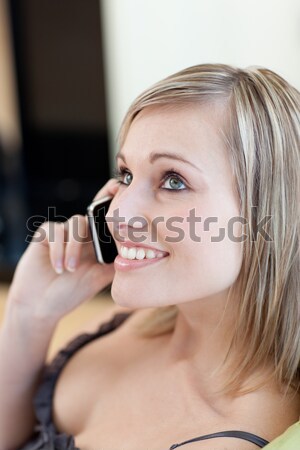 Stock photo: Joyful blonde woman listening to music with headphones against a black background