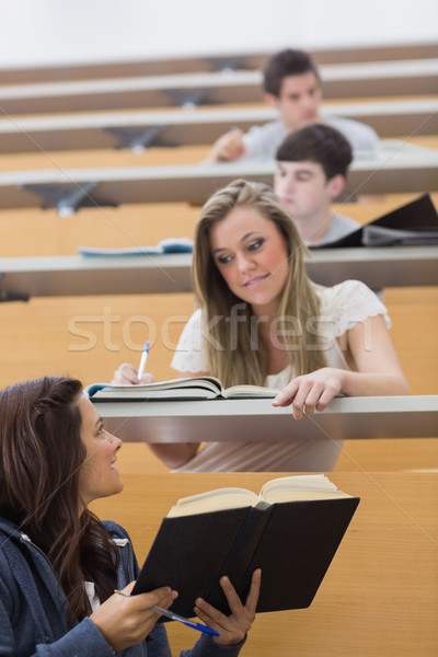 Stock photo: Student showing friend a book in the lecture hall