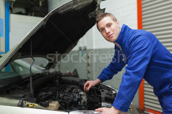 Confident mechanic checking car engine oil Stock photo © wavebreak_media