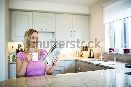 Nő sms üzenetküldés laptopot használ konyha portré fiatal nő Stock fotó © wavebreak_media