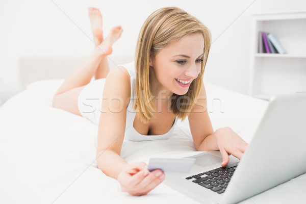 Foto stock: Casual · mulher · jovem · compras · on-line · cama · laptop · cartão · de · crédito