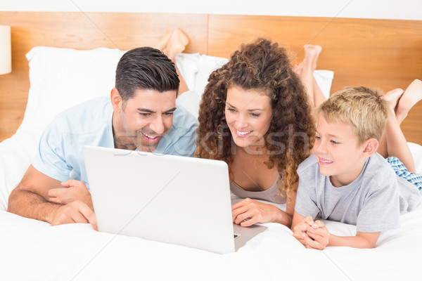 Happy family using laptop together on bed Stock photo © wavebreak_media
