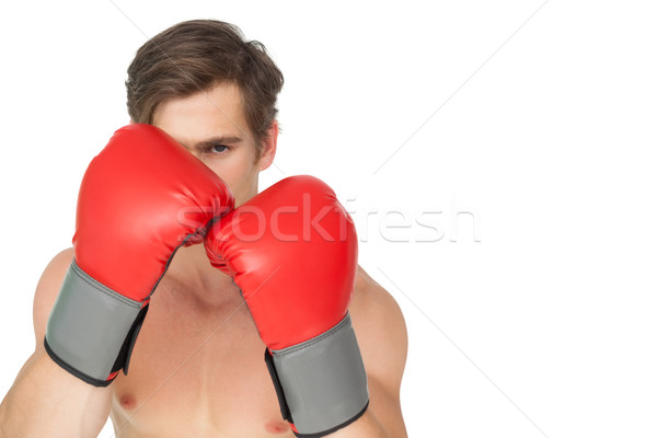 Tough man wearing red boxing gloves in guard position Stock photo © wavebreak_media