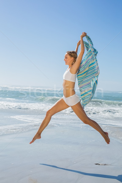 Stock photo: Gorgeous fit blonde leaping by the sea with scarf