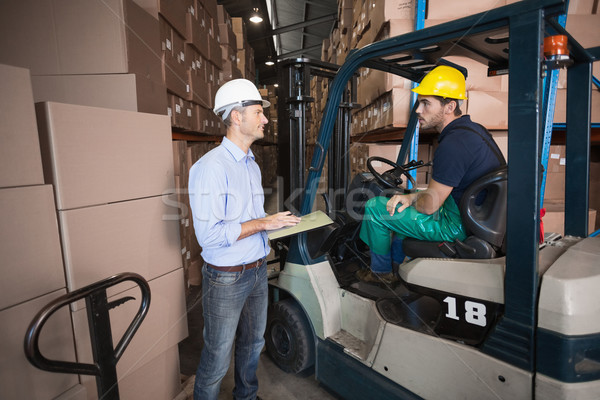 Warehouse manager talking with forklift driver Stock photo © wavebreak_media