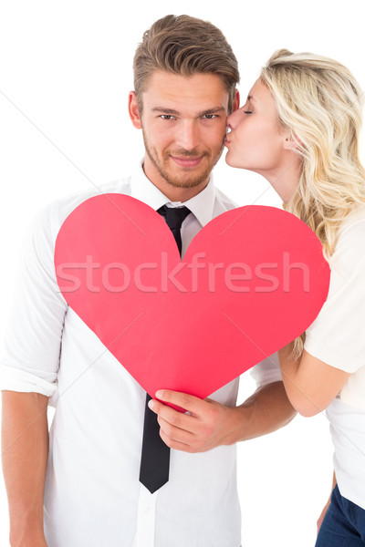 Woman kissing man as he holds heart Stock photo © wavebreak_media