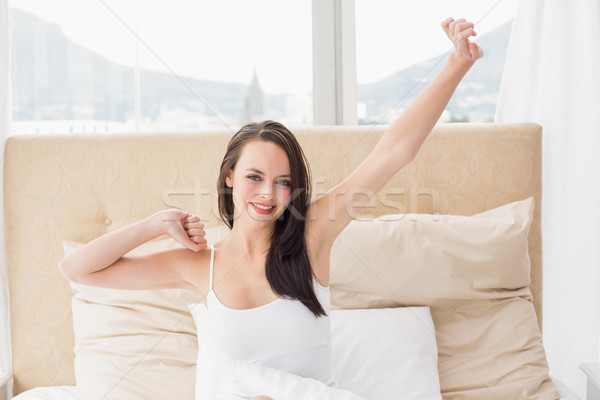 Pretty brunette stretching in bed Stock photo © wavebreak_media