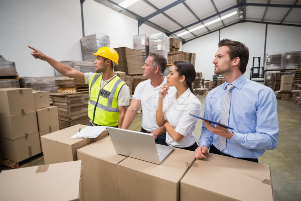 Warehouse worker pointing something to his colleagues Stock photo © wavebreak_media
