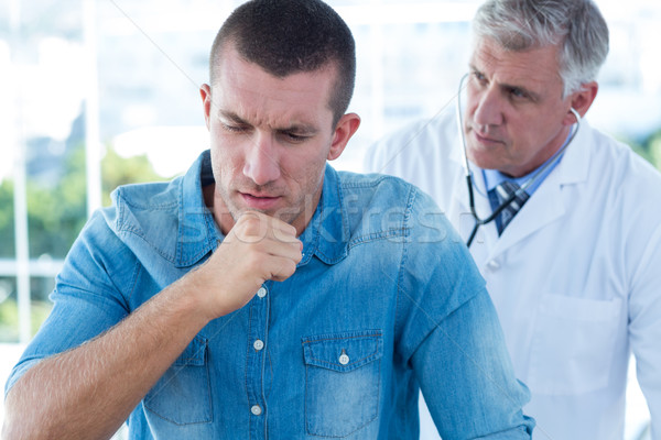 Stock photo: Doctor auscultating his patients back