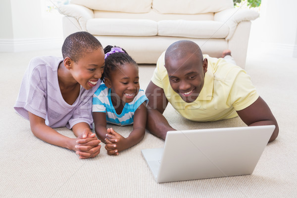 Foto stock: Feliz · sonriendo · Pareja · usando · la · computadora · portátil · hija · salón