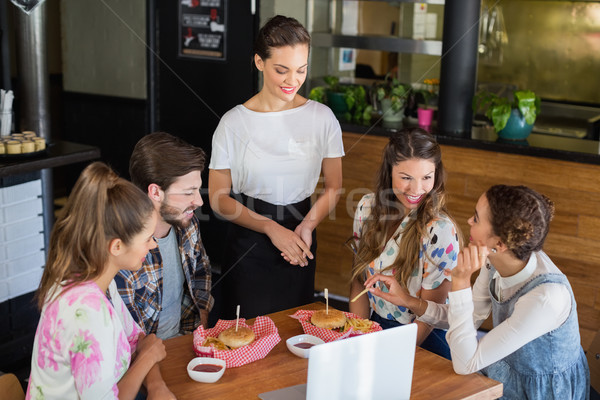 Stock photo: Waitress standing by customers in +restaurant