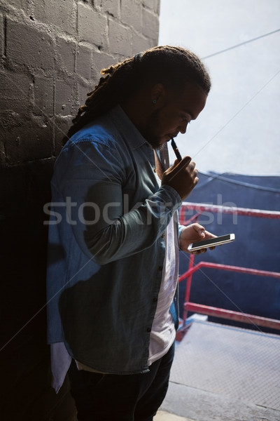 Foto stock: Hombre · fumar · teléfono · móvil · entrada · bar · vidrio