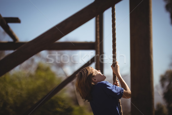 Determined girl climbing rope during obstacle course Stock photo © wavebreak_media