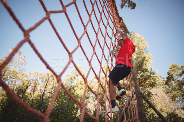 Portrait of happy boy climbing a net during obstacle course Stock photo © wavebreak_media