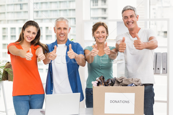 Casual business people donating and doing thumbs up Stock photo © wavebreak_media