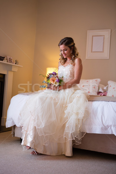 Gyönyörű menyasszony tart virágcsokor ül ágy Stock fotó © wavebreak_media