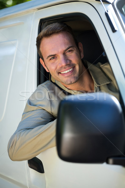 Stock photo: Delivery man driving in his van 