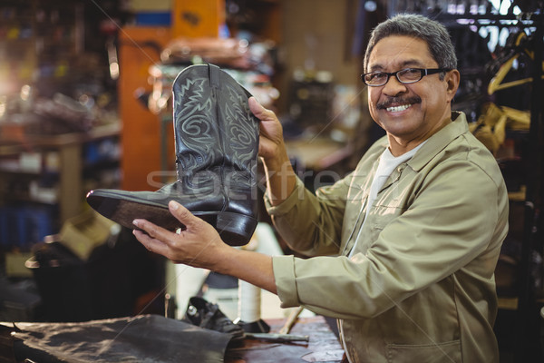 Portrait of smiling shoemaker holding a leather boot Stock photo © wavebreak_media