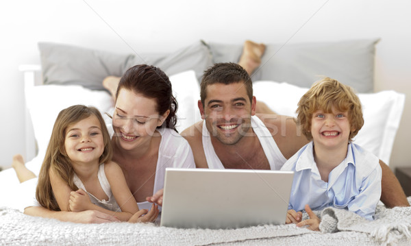 Familia cama usando la computadora portátil mujer nina sonrisa Foto stock © wavebreak_media