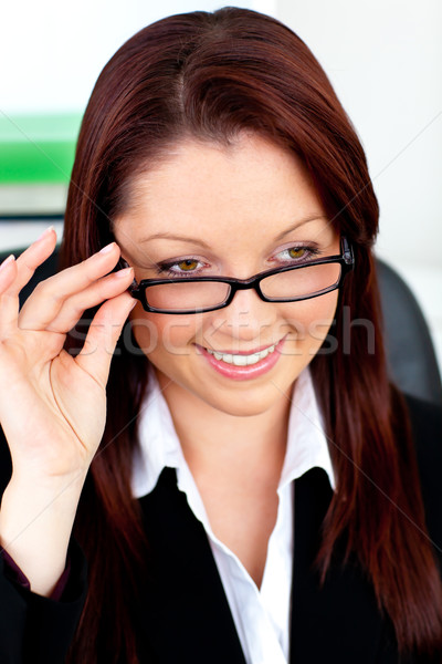 Smiling businesswoman holding her glasses sitting in her office at her desk Stock photo © wavebreak_media