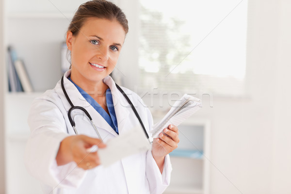 Charming brunette doctor handing out a prescription in the surgery Stock photo © wavebreak_media