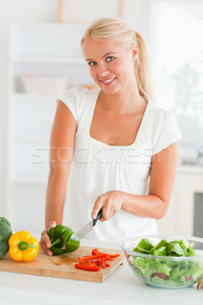 Lovely woman slicing pepper in her kitchen Stock photo © wavebreak_media