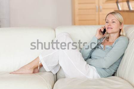 Stock photo: Woman lying on the floor while her fiance is reading a book in their living room