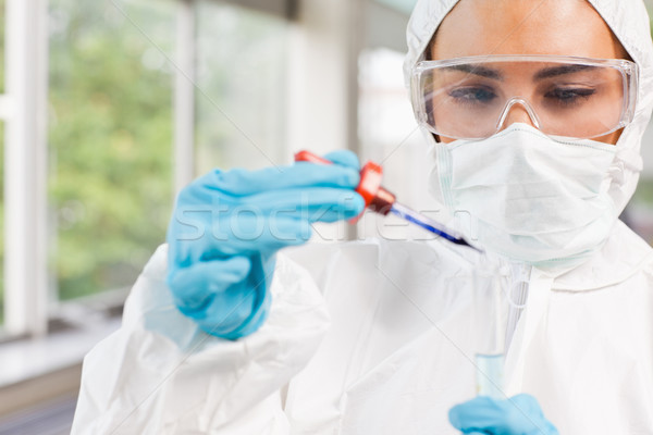Stock photo: Protected science student dropping a liquid in a test tube in a laboratory