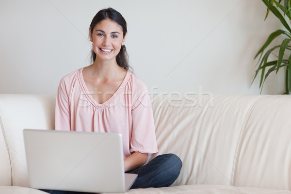 Stock photo: Woman using a notebook in her living room