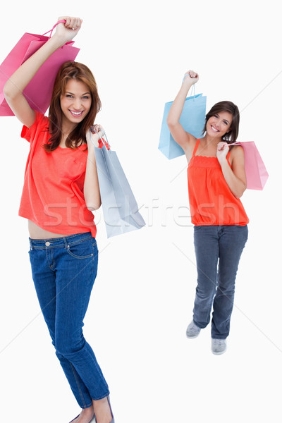 Teenage girl following a friend with purchase bags against a white background Stock photo © wavebreak_media