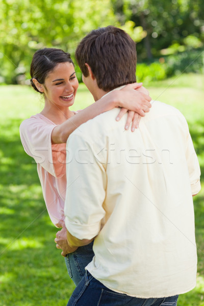 Woman laughing as she is holding onto the back of her friends neck in a park Stock photo © wavebreak_media