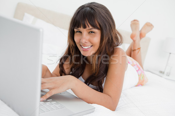 Retrato mujer sonriente portátil cama piernas Foto stock © wavebreak_media