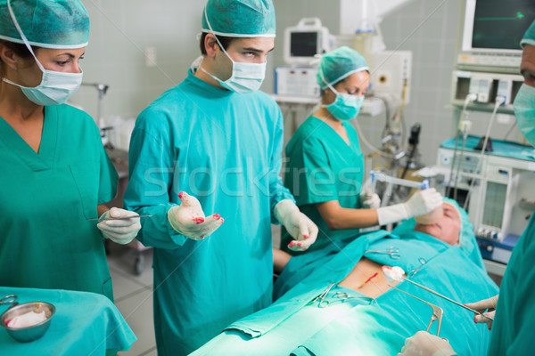 Surgeons standing next to a patient in an operating theatre Stock photo © wavebreak_media