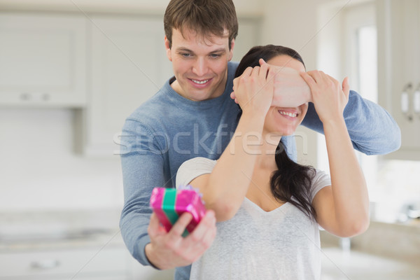 Husband surprising wife with gift at home Stock photo © wavebreak_media