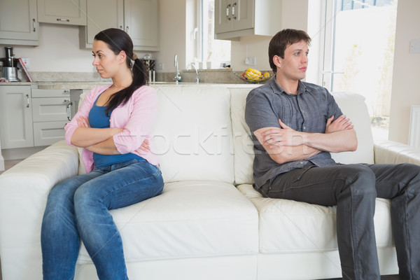 Stock photo: Two people sitting on the couch with crossing arms and falling quiet in the living room