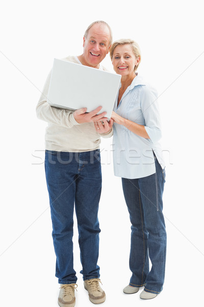 Mature couple smiling at camera with laptop Stock photo © wavebreak_media