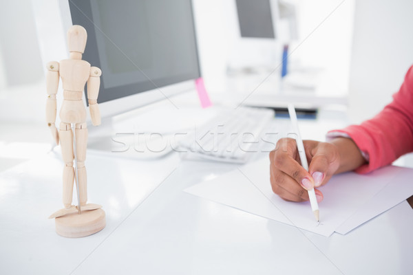 Stock photo: Casual graphic designer working at her desk sketching 