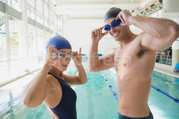 Stock photo: Fit couple swimmers by pool at leisure center