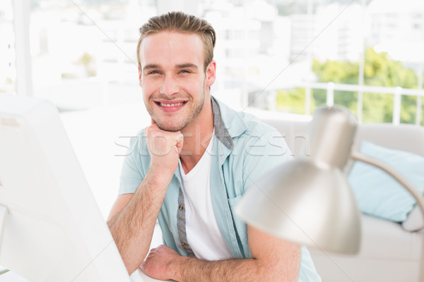 Smiling man using computer at his desk Stock photo © wavebreak_media